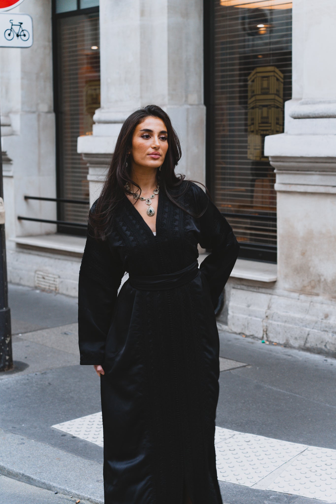 Une femme dans la rue qui porte un caftan marocain noir